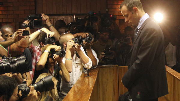FIE - In this Friday, Feb. 22, 2013 file photo photographers take photos of Olympic athlete Oscar Pistorius as he stands in the dock during his bail hearing at the magistrates court in Pretoria, South Africa. Double-amputee Olympic runner Oscar Pistorius 