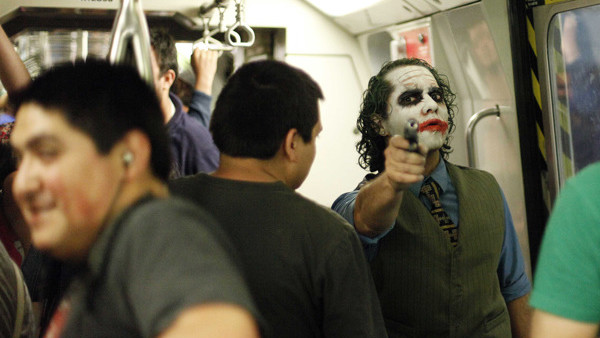 FILE - In this Oct. 31, 2014 file photo, a man dressed as DC Comics super villain The Joker points a toy gun as he strikes a pose in a subway car in Santiago, Chile. (AP Photo/Luis Hidalgo, File)