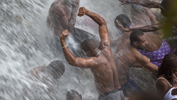 FILE - In this July 16, 2014 file photo, voodoo pilgrims bathe in a waterfall believed to have purifying powers during the annual celebration in Saut d' Eau, Haiti. The annual pilgrimage is made in honor of Haiti's most celebrated patron saint, Our Lady o