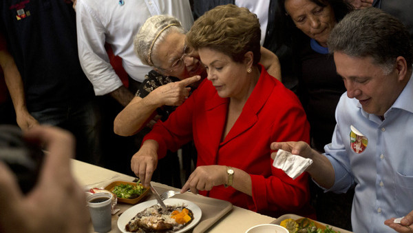 FILE - In this Aug. 27, 2014 file photo, a woman speaks strongly to Brazil's President Dilma Rousseff, who's running for reelection for the Workers Party (PT), as Rousseff makes a campaign stop at a popular restaurant in Rio de Janeiro, Brazil. Br