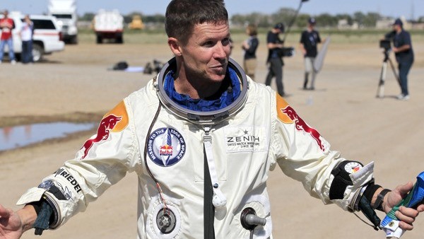 Felix Baumgartner, of Austria, gestures prior to speaking with the media after successfully jumping from a space capsule lifted by a helium balloon at a height of just over 128,000 feet above the Earth's surface, Sunday, Oct. 14, 2012, in Roswell, N.M. (A
