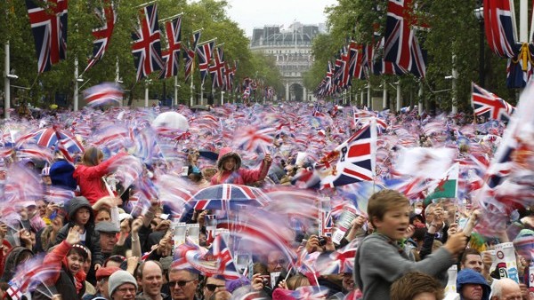FILE - In this June 5, 2012 file photo revelers on the Mall in London watch Britain Queen Elizabeth II appear on the Buckingham Palace balcony as part of a four-day Diamond Jubilee celebration to mark the 60th anniversary of Queen Elizabeth II accession t