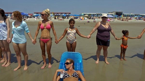 FILE - People hold hands during a Hands Across the Sand event in Tybee Island, Ga., in this file photo taken June 26, 2010, about two months after the explosion of the Deepwater Horizon oil rig in the Gulf of Mexico. A high-stakes trial to assign blame an