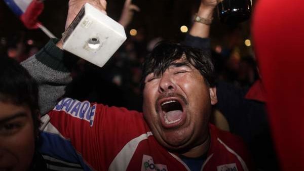 A man celebrates while watching on TV the rescue of the first trapped miner, Florencio Avalos, in Copiapo, Chile, early Wednesday Oct. 13, 2010. Thirty-three miners became trapped when the gold and copper mine collapsed on Aug. 5. (AP Photo/Dario Lopez-Mi