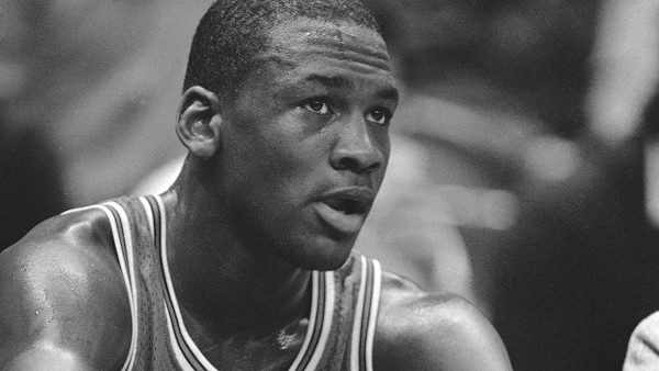 Chicago Bulls rookie Michael Jordan takes a break on the bench and watches his teammates battle the Golden State Warriors in Oakland, Calif., Nov. 28, 1984. Jordan, who has been averaging 27 points per game, scored just 13 points, his lowest total as a pr