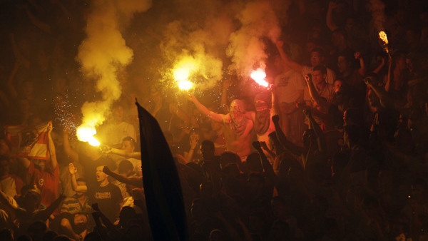 Red Star soccer fans react during a Serbian National league soccer match against Partizan, in Belgrade, Serbia, Saturday, May 18, 2013. Thousands of riot policemen have been deployed throughout Belgrade to prevent possible violence during a derby match be