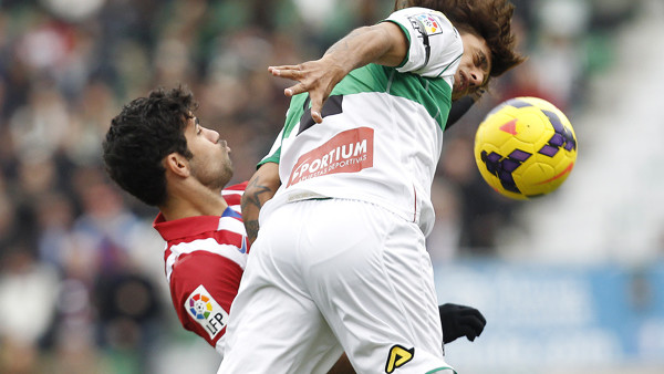Atletico Madrid's Diego Costa, left, duels for the ball with Elche's Damian Nicolas Suarez , right, during their La Liga soccer match at the Manuel Martinez Valero stadium in Elche, Spain, Saturday, Nov. 30, 2013. (AP Photo/Alberto Saiz)