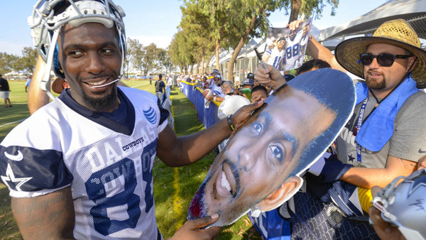 Dallas Cowboys wide receiver Dez Bryant is handed a large cutout photo of his head to sign after afternoon practice during NFL football training camp, Friday, July 31, 2015, in Oxnard, Calif. (AP Photo/Gus Ruelas)